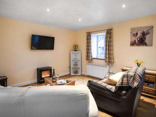 a living room with a couch and a fireplace at Cut Lloi in Llanfair Caereinion
