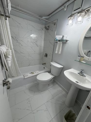 a white bathroom with a toilet and a sink at Casablanca Oceanside Inn in Ocean City