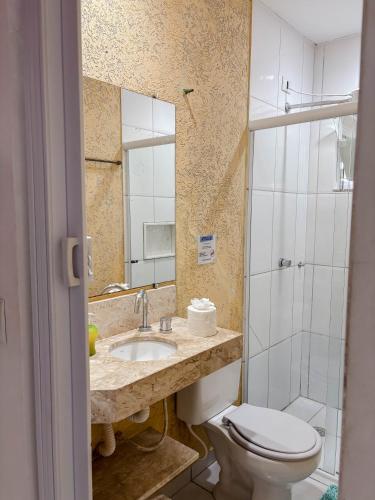 a bathroom with a toilet and a sink and a mirror at Casa Sossego Com Piscina Aquecida, Hidro e Cascata in Peruíbe