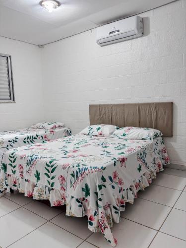 two beds sitting next to each other in a room at Casa Sossego Com Piscina Aquecida, Hidro e Cascata in Peruíbe