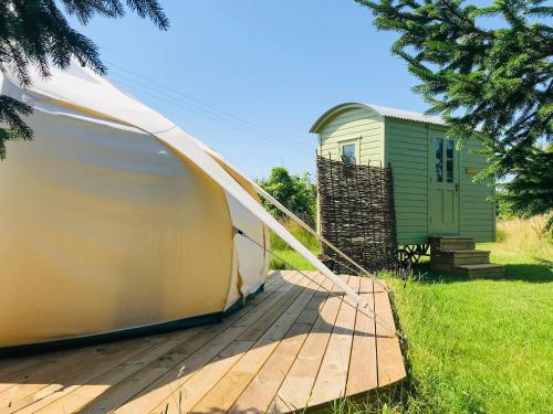 a tent on a wooden deck in front of a building at Shepherds Belle & Croft Hut - Qu7633 in Messing