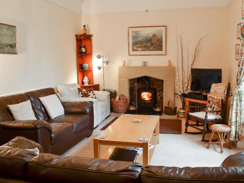 a living room with leather furniture and a fireplace at The Old King's Head Pickering in Pickering