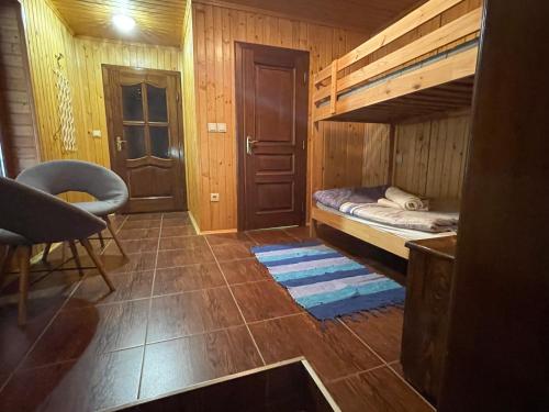 a small room with a bunk bed and a chair at Guest house Nad Tisou in Kvasy