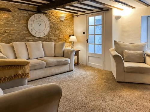 a living room with a couch and two chairs at Hailey Cottage in Chipping Norton