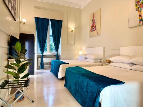 a hotel room with two beds and a plant at Spanish Steps Boutique Hotel - Madame Sofia Secret Hotel in Rome