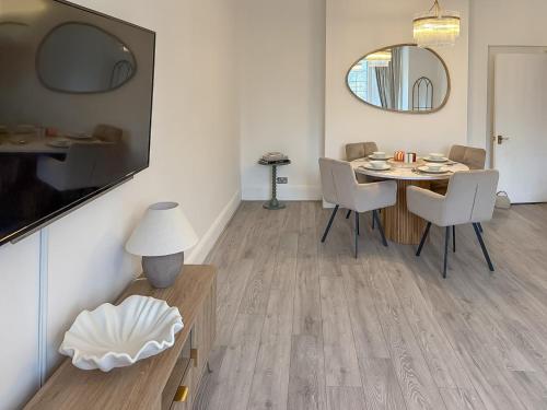 a dining room with a table and chairs and a mirror at Joss Bay Days in Broadstairs