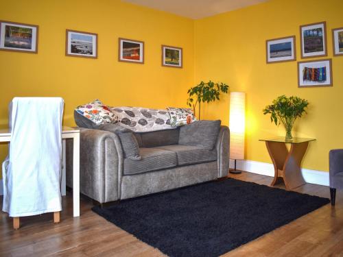 a living room with a couch and yellow walls at Little Gubbs in West Buckland