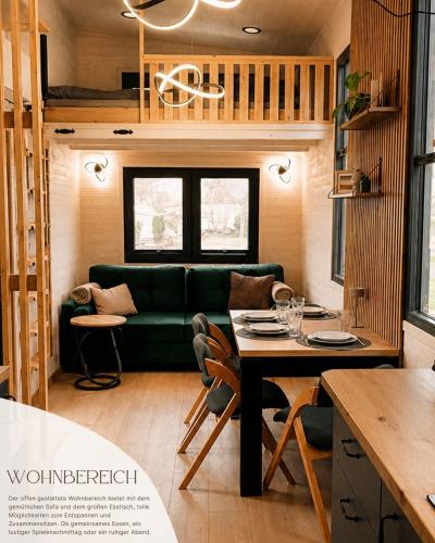 ein Wohnzimmer mit einer grünen Couch und einem Tisch in der Unterkunft Tinyhouse WeserNest in Sandstedt