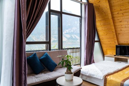 a living room with a couch and a large window at KDL Pauon Ecolakes in Quỳnh Nhai