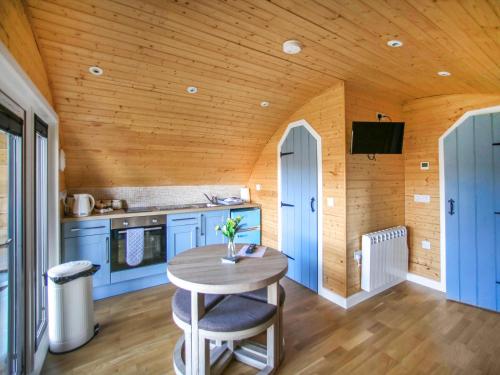 a kitchen with blue cabinets and a wooden ceiling at Dougie's Pod in Acharacle