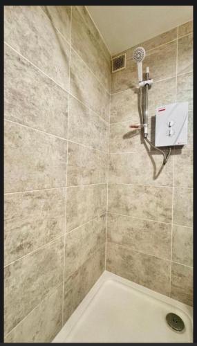 a bathroom with a shower with a shower head at Super-King Room Tobermory with shared bathroom in Tobermory