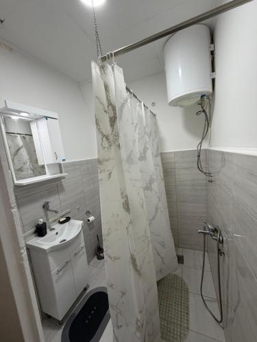 a bathroom with a shower curtain and a sink at Apartman Velić in Bor
