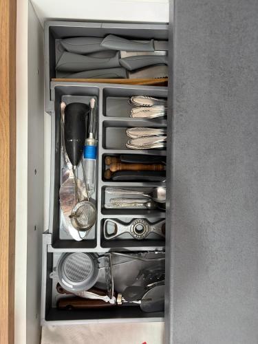a drawer full of utensils in a cabinet at Apartman Velić in Bor