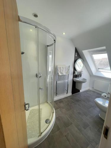 a bathroom with a glass shower and a toilet at Boathouse Hotel in Hythe