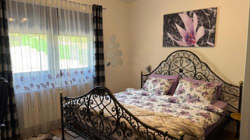 a bedroom with a metal bed with a window at Apartmani Hrastik 1 in Bihać
