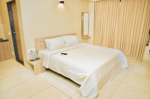 a bedroom with a large white bed in a room at Hotel Shri Ram Residency in Belgaum