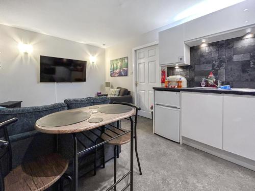 a kitchen and a living room with a table at The Lade in Kilsyth