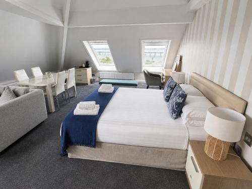a bedroom with a large bed and a table at Boathouse Hotel in Hythe