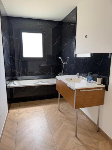 a bathroom with a sink and a bath tub at Villa eger in Ruoms