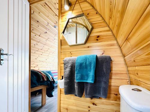 a bathroom with a wooden wall with a sink and towels at Brora Escapes in Brora