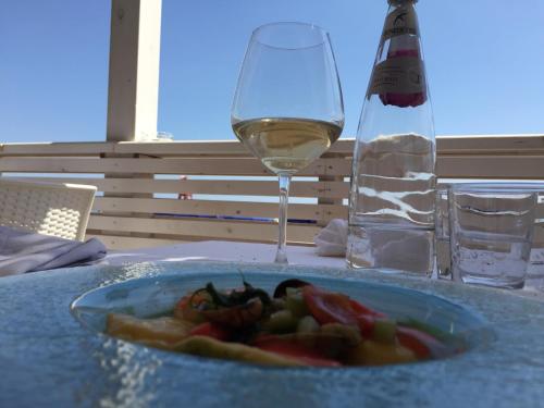 um prato de comida e um copo de vinho numa mesa em Da Nino e Maria em Marina di Modica