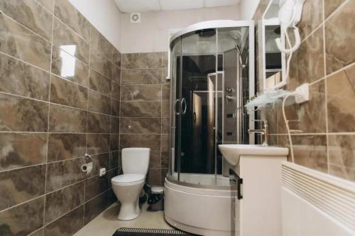 a bathroom with a toilet and a sink at PANORAMA HOTEL in Tyachiv