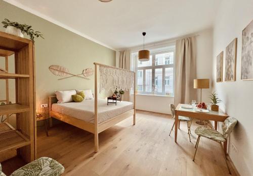 ein Schlafzimmer mit einem Bett, einem Tisch und einem Schreibtisch in der Unterkunft SERVUS HOMES Schönbrunn I Top-Lage & Metro in Wien