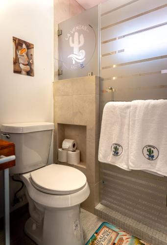 ein Badezimmer mit weißer Toilette und Handtüchern in der Unterkunft Beach Front Lux Containers in La Ventana