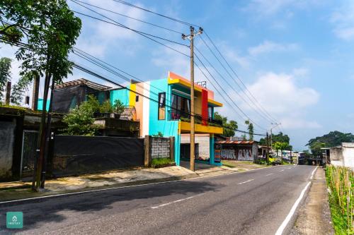 a colorful house on the side of a street at INSTAY Hotel Dieng Chill Serenity in Garung