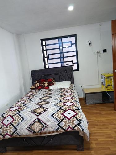 a bedroom with a bed with a quilt on it at Casa en Sur de Quito in Quito