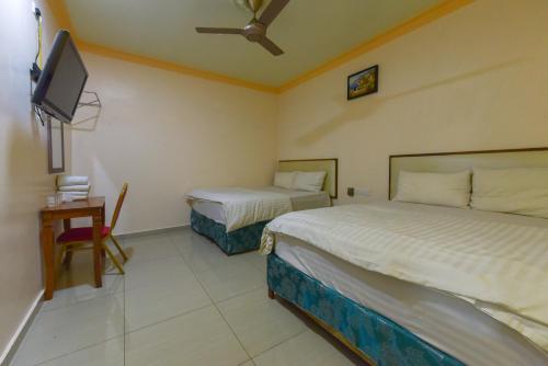 a hotel room with two beds and a tv at SMC Hotel Alam Avenue in Shah Alam