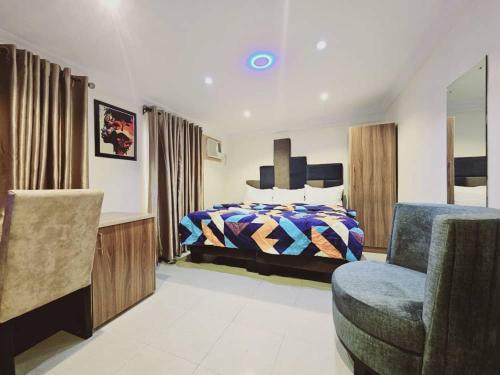 a bedroom with a bed and a chair at Summer Breeze Guest House in Suru Lere