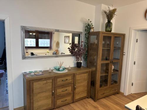 a kitchen with a wooden cabinet and a mirror at Apartmani Hrastik 1 in Bihać