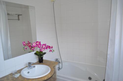 a bathroom with a sink and a vase of flowers at Quinta da Mesquita in Pêra