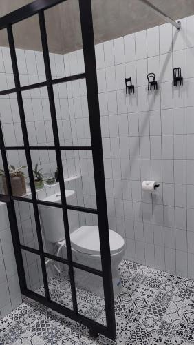 a bathroom with a toilet in a tiled room at The Yoora Villa in Ngadipuro