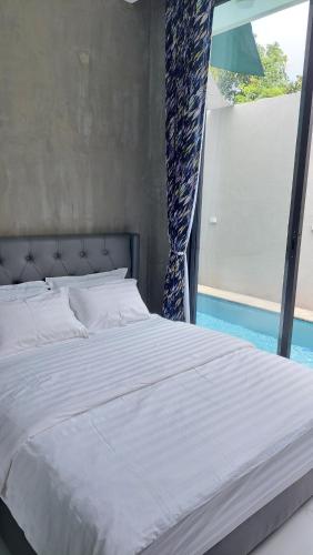 a bed in a bedroom with a large window at The Yoora Villa in Ngadipuro