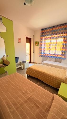 a hotel room with two beds and a window at La casa al mare in Grottammare
