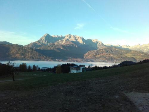 a view of a mountain range with a house and a lake at Zistelberghof in Werfenweng