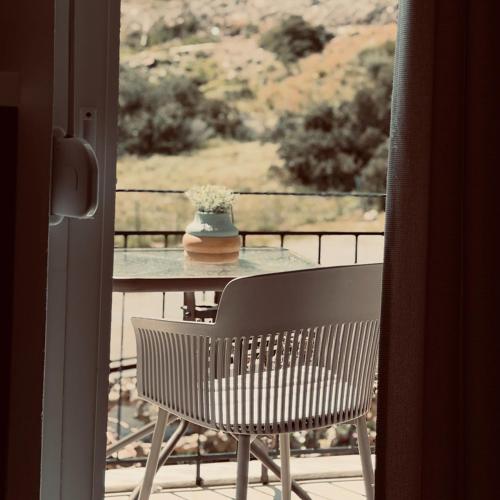 a table with a vase of flowers on a balcony at Stelios Studios Sougia in Sougia