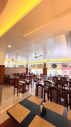 a restaurant with tables and chairs and a person laying on the table at Aira Residency in Vennikulam