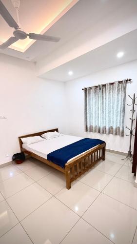 a bed in a white room with a ceiling at Aira Residency in Vennikulam