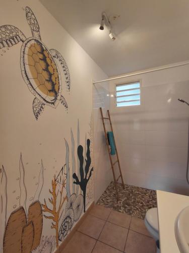 a bathroom with a turtle mural on the wall at GîteTi Coco de Malendure - Bord de mer - 4 pers in Bouillante