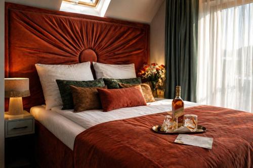 a bedroom with a large bed with a bottle of wine at NovaWisła Resort & SPA in Wisła