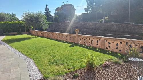 a garden with a retaining wall and green grass at La tana del geco in Iseo