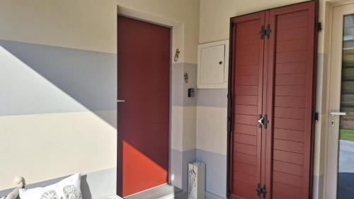 a room with a red door and a bed at La tana del geco in Iseo