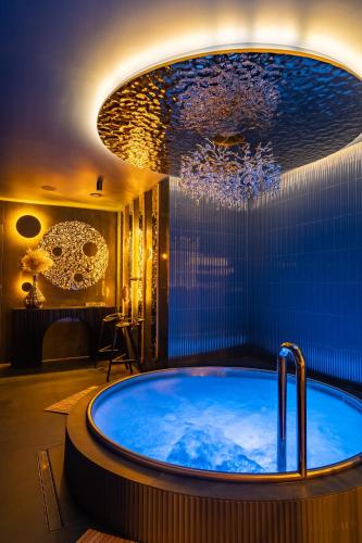 a bathroom with a large tub with a chandelier at NovaWisła Resort & SPA in Wisła