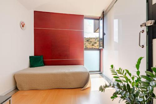 a room with a bed with a red wall at Beach LOFT Tabaiba in Tabaiba