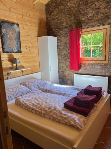a bed in a room with a red window at Apartma Suzy in Pobegi