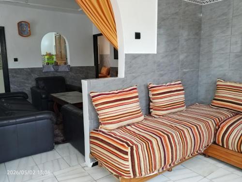 a couch with two pillows and a living room at Cabanon plage david in Bouznika