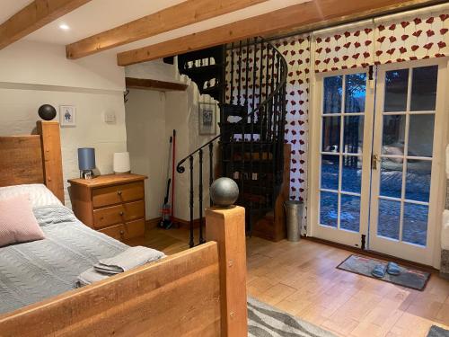 a bedroom with a bed and a glass door at Tredrea Annexe - Self Contained Cornish hideaway in Truro